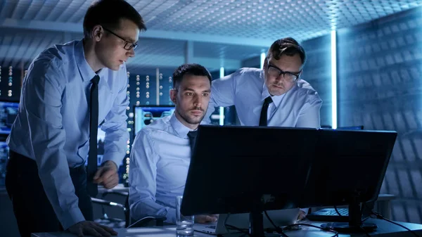 Technical team working at computer screens